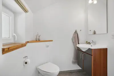 a white bathroom with a toilet and a sink at JB228-Brovst-Ildervej-14 in Brovst