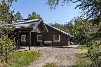 a small house with a bench in front of it at JB228-Brovst-Ildervej-14 in Brovst
