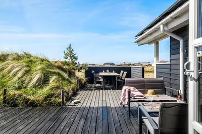 a wooden deck with a table and chairs on a house at JB230-Frostrup-Grabakkevej-4 in Frøstrup