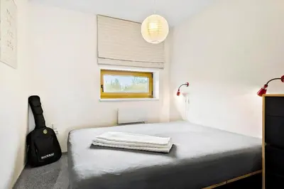 a bedroom with a bed with a suitcase and a window at JB227-Frostrup-Andreas-Lassens-Vej-16 in Frøstrup