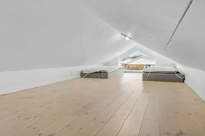 two beds in an attic room with a wooden floor at JB308-Fjerritslev-Slettestrandvej-134-lejl-3 in Fjerritslev