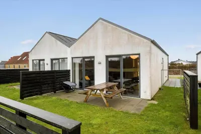 a white house with a picnic table in the yard at JB308-Fjerritslev-Slettestrandvej-134-lejl-3 in Fjerritslev