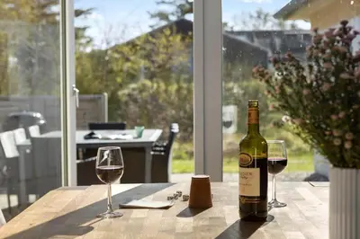 a bottle of wine sitting on a table with two glasses at JB149-Fjerritslev-Tulipanvej-23 in Fjerritslev