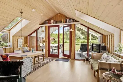 a living room with sliding glass doors and a table at JB361-Fjerritslev-Lyngbjergvej-58 in Fjerritslev