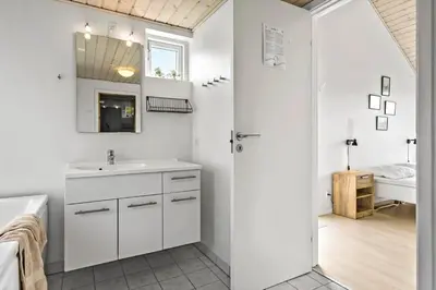 a white bathroom with a sink and a mirror at JB359-Brovst-Kronvildtvej-242 in Brovst