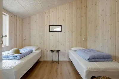 two beds in a room with wooden walls at JB351-Fjerritslev-Revlingestien-77 in Fjerritslev