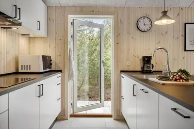 a kitchen with white cabinets and a clock on the wall at JB351-Fjerritslev-Revlingestien-77 in Fjerritslev