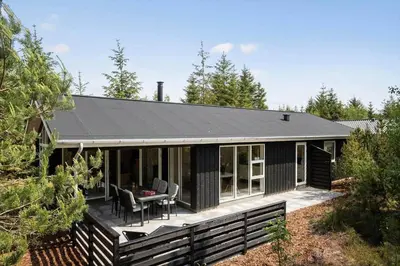 a small black house with a table and chairs at JB351-Fjerritslev-Revlingestien-77 in Fjerritslev