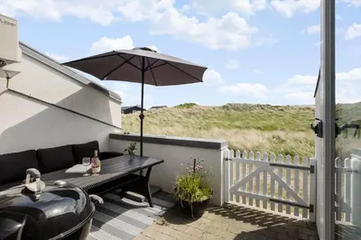 a patio with a table with an umbrella and a grill at JB358-Brovst-Strandvejen-150-Lejl-126 in Brovst