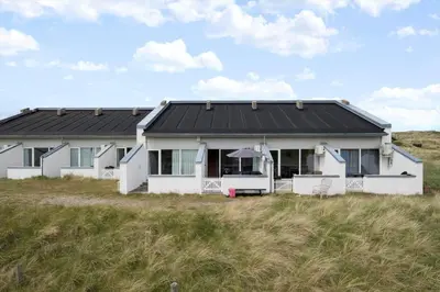 a white house with a black roof in a field at JB358-Brovst-Strandvejen-150-Lejl-126 in Brovst
