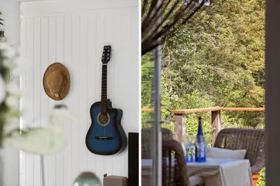a guitar hanging on a wall next to a table at JB401-Brovst-Solsortevej-1 in Brovst