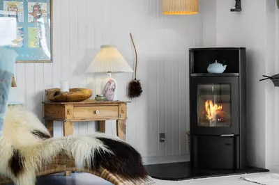 a living room with a fireplace and a table with a lamp at JB401-Brovst-Solsortevej-1 in Brovst