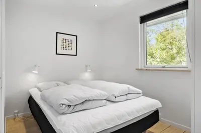 a white bedroom with a bed with pillows on it at JB400-Brovst-Solsortevej-7 in Brovst
