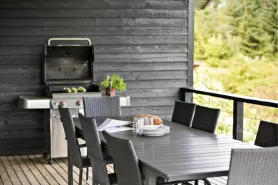 a table and chairs on a deck with a grill at JB400-Brovst-Solsortevej-7 in Brovst
