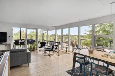a living room with a couch and a table and chairs at JB400-Brovst-Solsortevej-7 in Brovst
