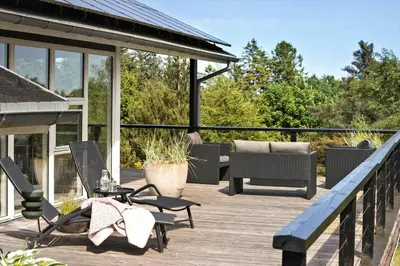 a deck with a couch and a table and chairs at JB400-Brovst-Solsortevej-7 in Brovst