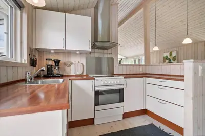 a kitchen with white cabinets and a sink and a stove at JB209-Fjerritslev-Egevej-22 in Fjerritslev