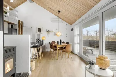 a kitchen and dining room with a table and a fireplace at JB316-Brovst-Kronvildtvej-250 in Brovst