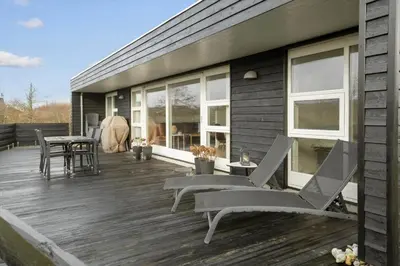 a deck with chairs and tables on a house at JB316-Brovst-Kronvildtvej-250 in Brovst