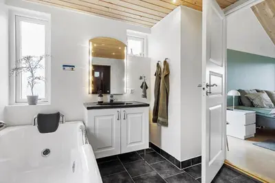 a bathroom with a white tub and a sink at JB316-Brovst-Kronvildtvej-250 in Brovst