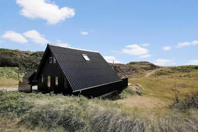 a black house sitting on top of a hill at 850-Thisted-Sandvej-19 in Thisted