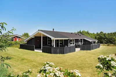 a black house with a large yard at LK1902-Lokken-Olgavej-40 in Løkken