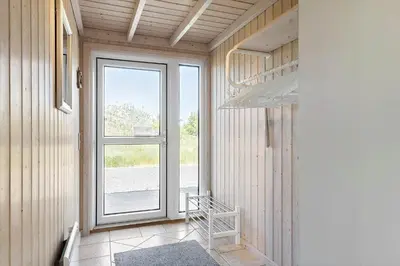 a hallway with a large window and a staircase at LK1902-Lokken-Olgavej-40 in Løkken