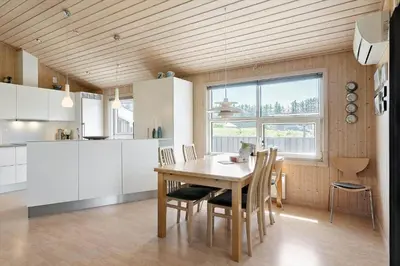 a kitchen with a table and chairs in a room at LK1902-Lokken-Olgavej-40 in Løkken
