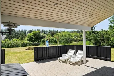 a group of white chairs sitting on a patio at LK1902-Lokken-Olgavej-40 in Løkken