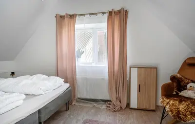 a bedroom with a bed and a window and a chair at 2 Bedroom Amazing Home In Thyholm in Thyholm