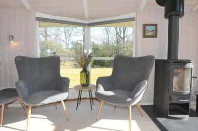 two chairs in a living room with a wood stove at 80153-Vemb-Knudehus-49 in Vemb