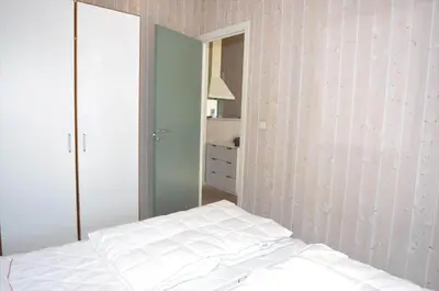 a bedroom with a white bed and a mirror at 80153-Vemb-Knudehus-49 in Vemb