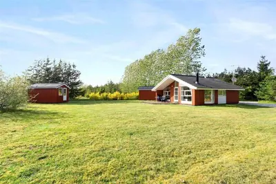 a small house on a grassy field with a building at 80153-Vemb-Knudehus-49 in Vemb