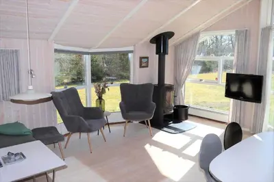 a living room with chairs and a wood stove at 80153-Vemb-Knudehus-49 in Vemb