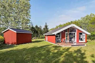 a red shed with a deck in a yard at 80153-Vemb-Knudehus-49 in Vemb
