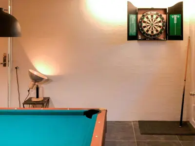 a room with a pool table and a dartboard on the wall at Family-Friendly House with Sauna in Pandrup