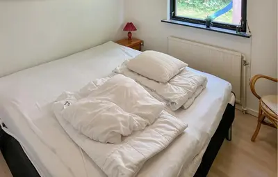 a bed with white sheets and pillows on it at Pet Friendly Home In Struer With Wifi in Struer