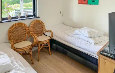 a bedroom with two chairs and a bed with a window at Pet Friendly Home In Struer With Wifi in Struer