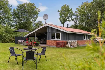 a small house with a table and chairs in the yard at JB162-Fjerritslev-Ronnevej-4 in Fjerritslev
