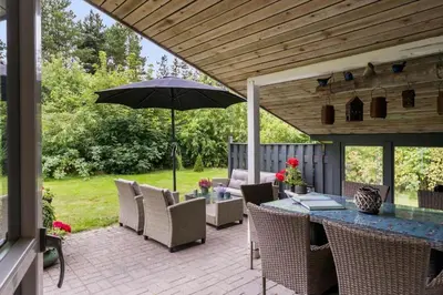 a patio with a table and an umbrella at JB162-Fjerritslev-Ronnevej-4 in Fjerritslev