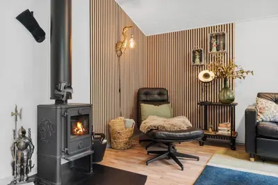 a living room with a wood stove and a chair at JB162-Fjerritslev-Ronnevej-4 in Fjerritslev