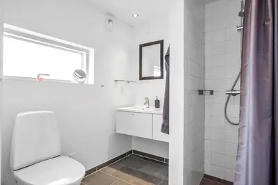 a white bathroom with a toilet and a sink at JB366-Brovst-Kronvildtvej-118 in Brovst