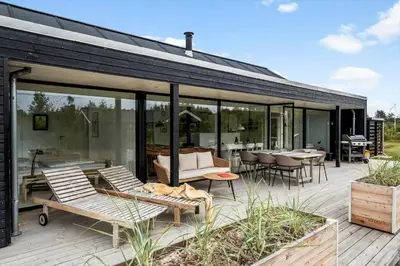 a patio with chairs and tables in a house at JB366-Brovst-Kronvildtvej-118 in Brovst