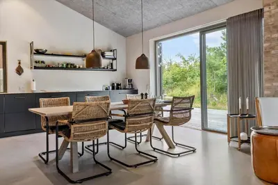 a kitchen with a dining room table and chairs at LK2174-Lokken-Stellavej-18 in Løkken
