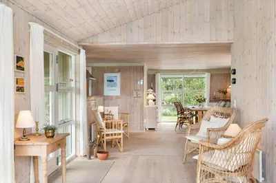 a room with wicker chairs and a dining room at LK2178-Lokken-Sarasvej-48 in Løkken