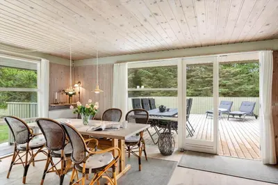 a dining room with a table and chairs on a deck at LK2178-Lokken-Sarasvej-48 in Løkken