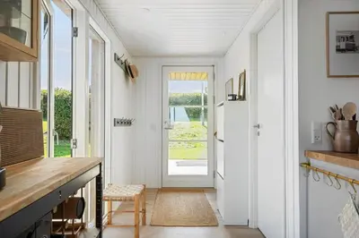 a hallway with a door leading to a kitchen with white walls at G322-Lemvig-Gyvelvej-22 in Lemvig