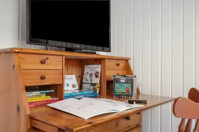 a desk with a television on top of a wooden dresser at G322-Lemvig-Gyvelvej-22 in Lemvig