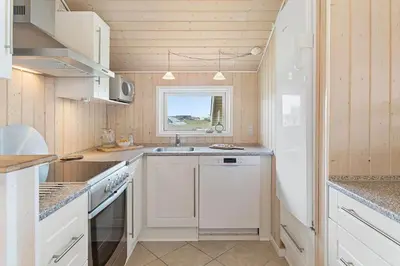 a small kitchen with white appliances and a window at 814-Harboore-Neerlandiavej-176 in Harboør
