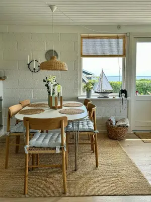 a dining room with a table and chairs and a window at Beach Hotel Inspired Holiday Home By Limfjorden in Snedsted